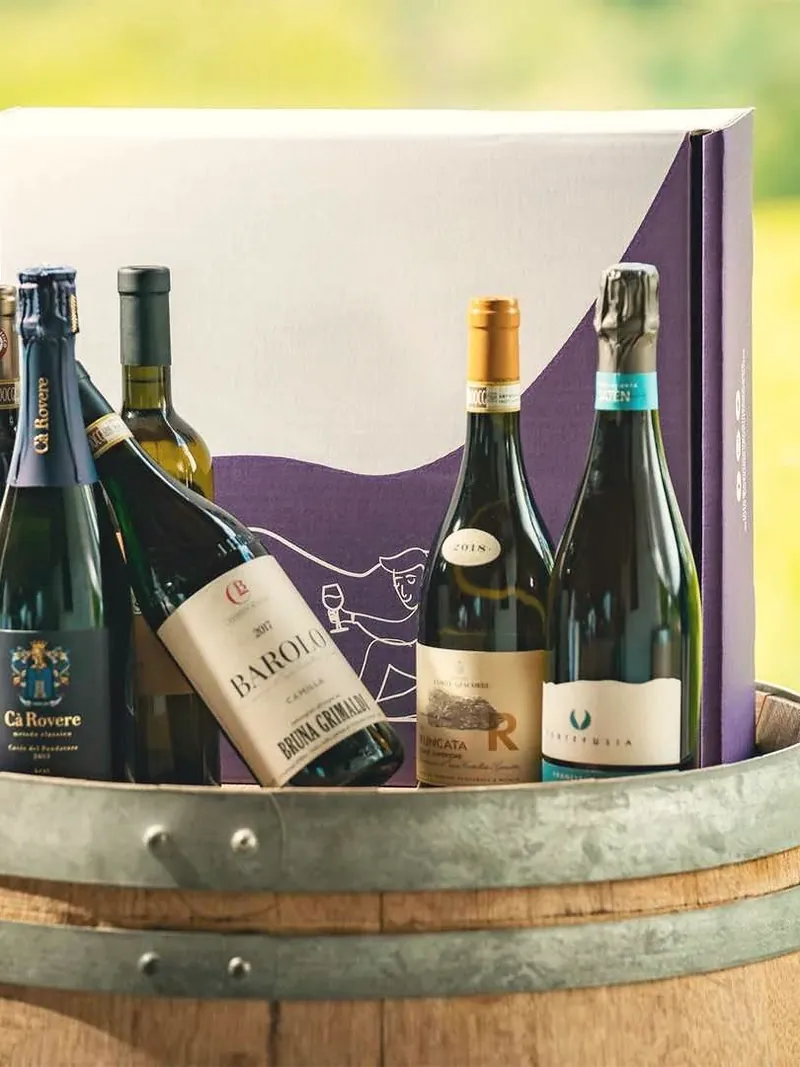 Bottiglie di vino davanti alla confezione, su un barile